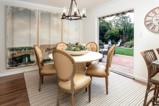 Art on the wall from ceiling to the floor. Striped rug (brown and white). Modren looking dining room. French doors are open into the backyard. Make A Small Room Look Bigger 